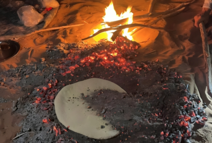 Pain nomade en train de cuire sous les braises d'un feu de camp - Grain de sable du Maroc